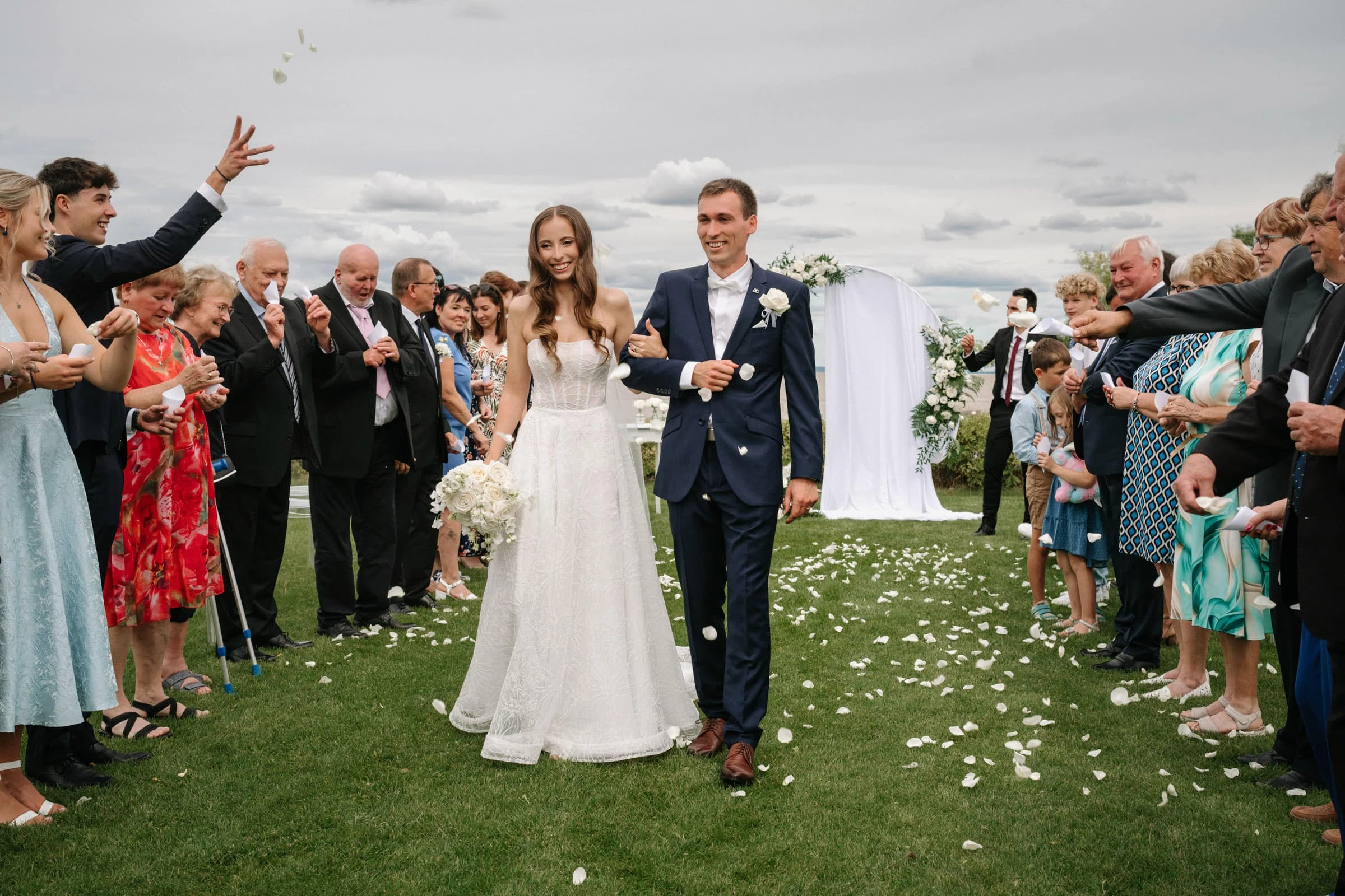 Novomanželé procházejí alejí stromů